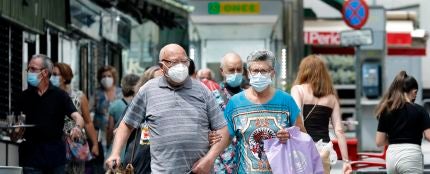 Varias personas en los alrededores del mercado del barrio de Collblanc de L'Hospitalet (Barcelona)