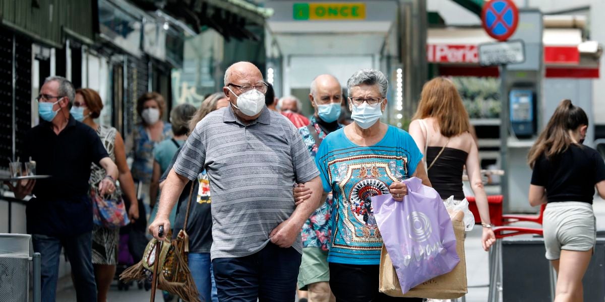 Varias personas en los alrededores del mercado del barrio de Collblanc de L'Hospitalet (Barcelona)