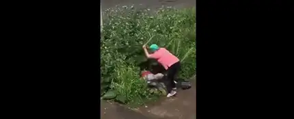 Una mujer golpea violentamente a una pareja que practica sexo en un arbusto Una mujer golpea violentamente a una pareja que practica sexo en un arbusto