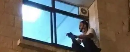 El joven palestino subido a la ventana del hospital para despedirse de su madre tras el cristal El joven palestino subido a la ventana del hospital para despedirse de su madre tras el cristal