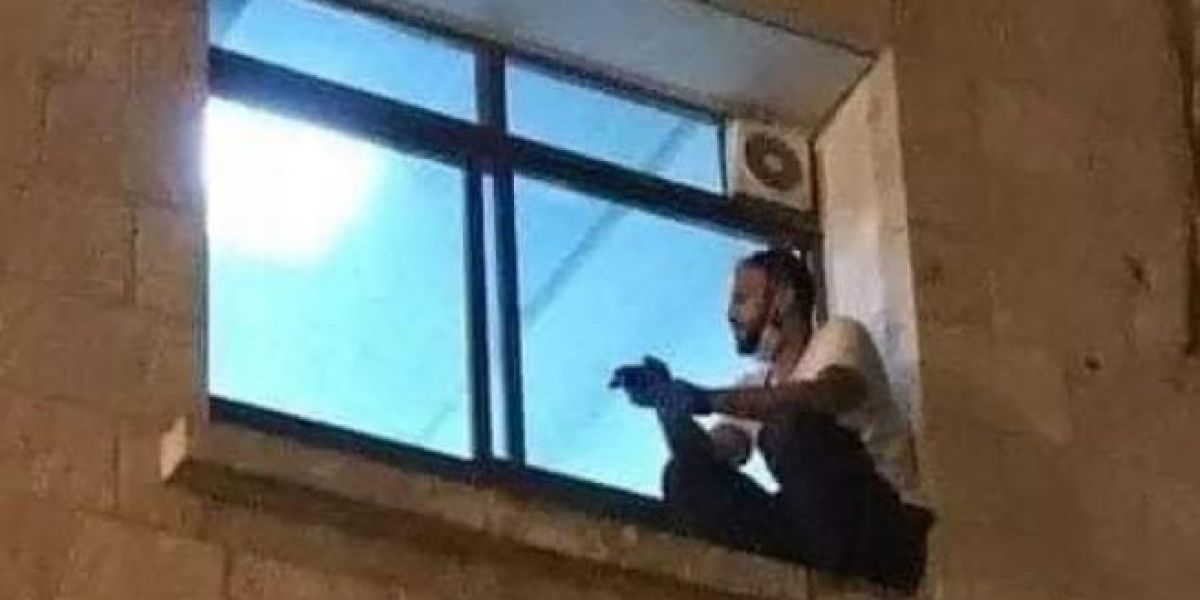 El joven palestino subido a la ventana del hospital para despedirse de su madre tras el cristal