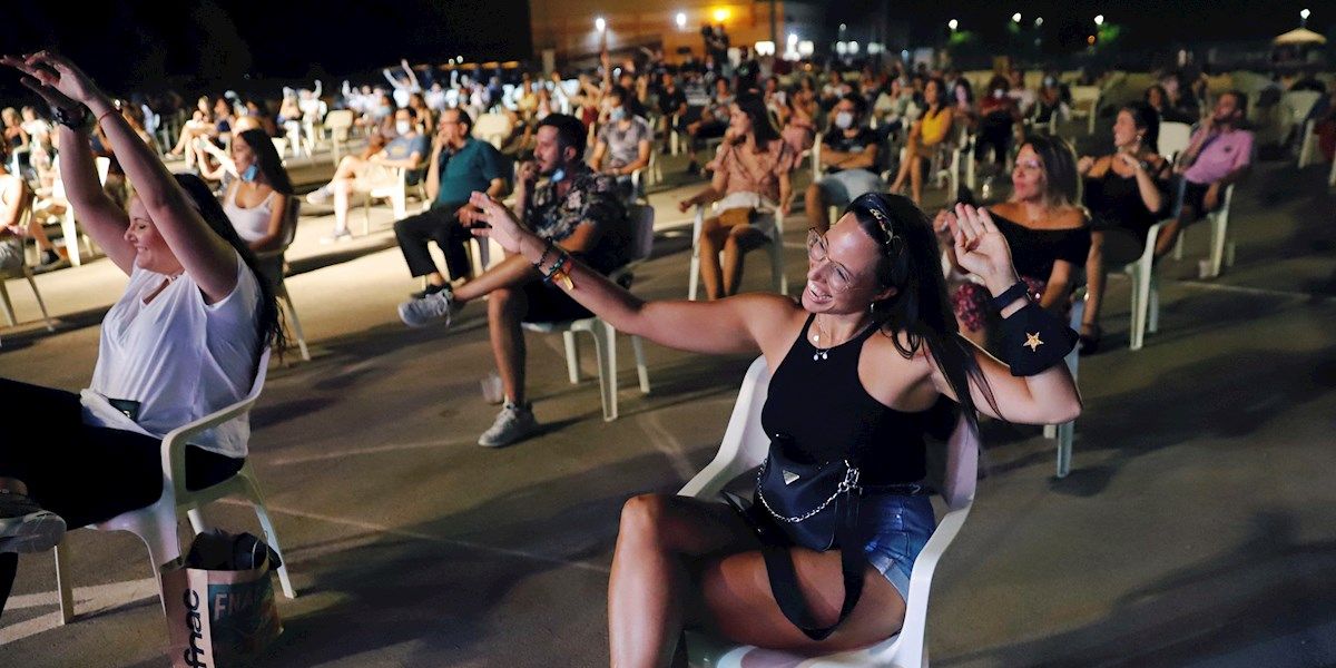 Jóvenes bailan sentados en el festival "Live Mar Menor" guardando la distancia