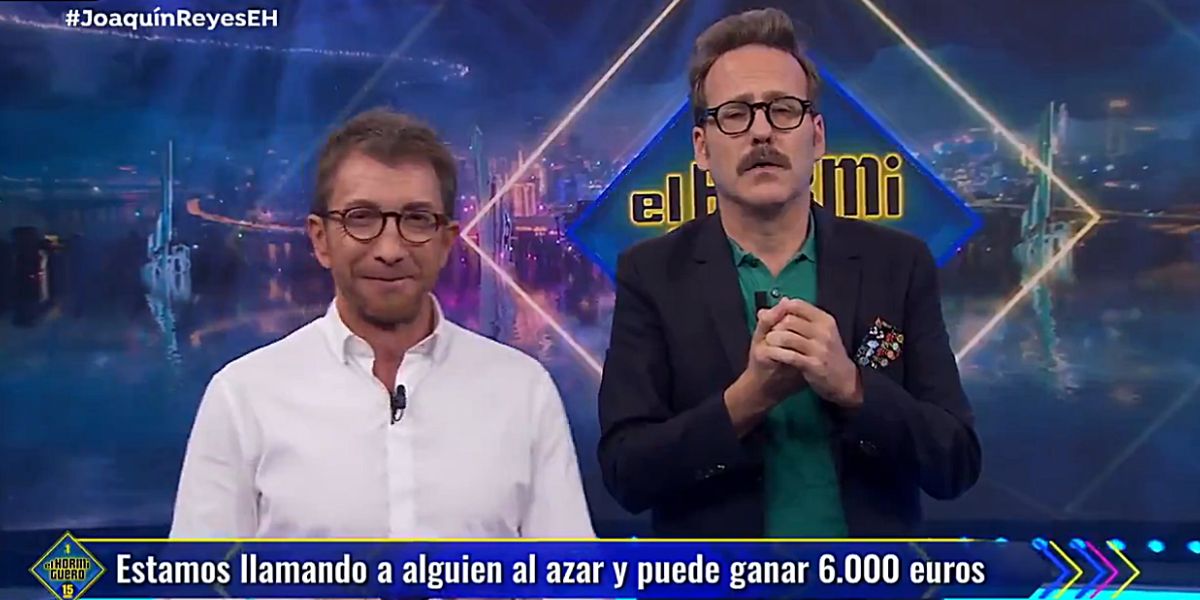 Pablo Motos y Joaquín Reyes intentando repartir la tarjeta de El Hormiguero