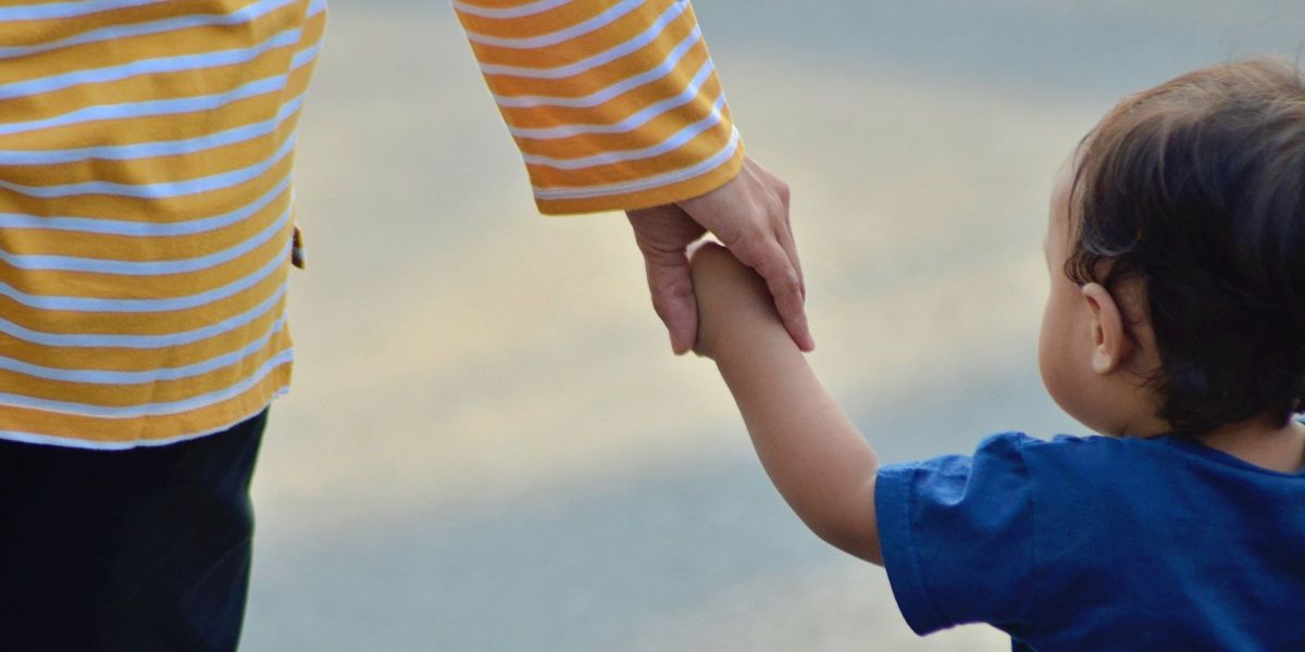 Un niño pequeño pasea de la mano de su madre.
