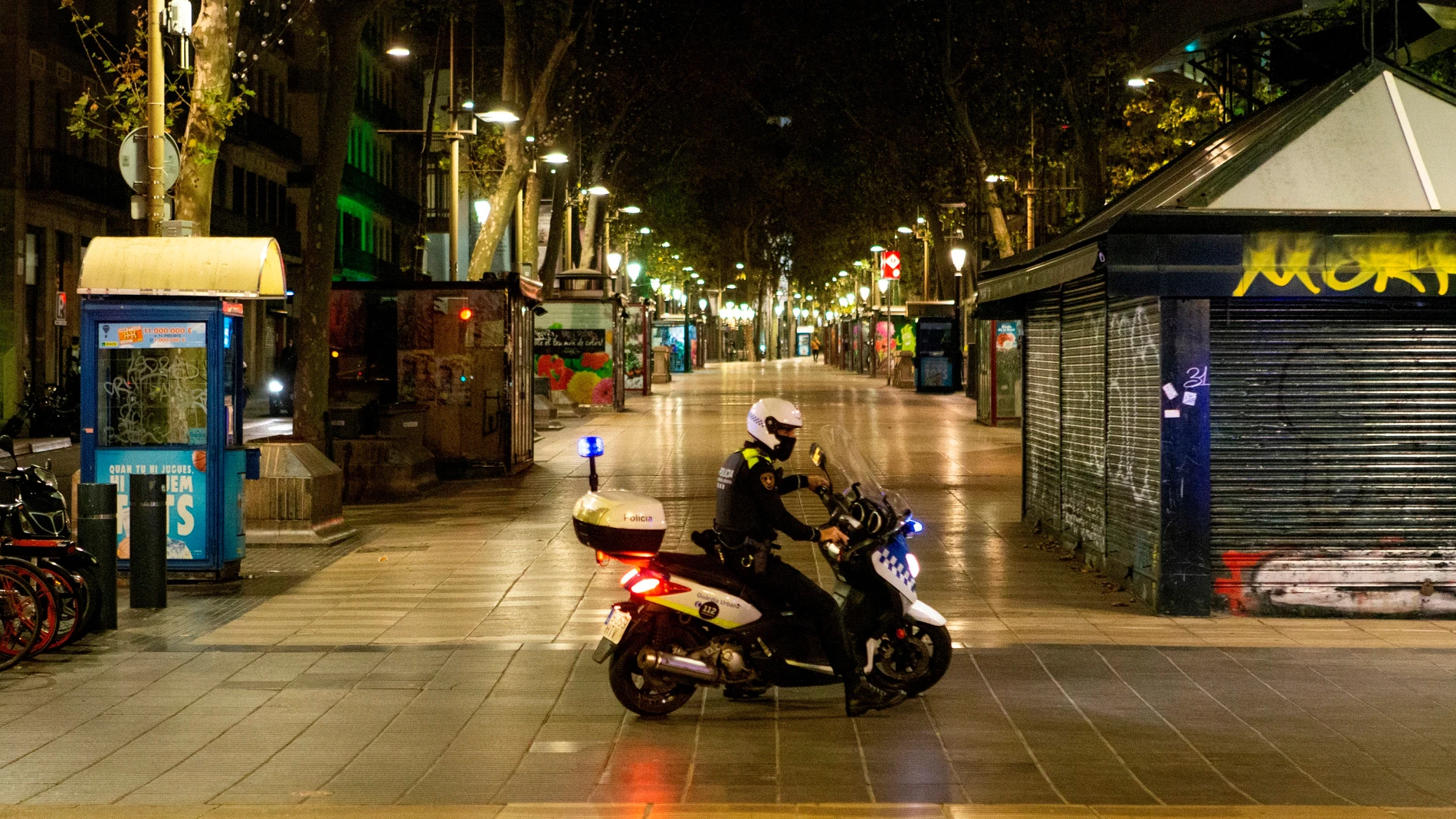Imagen de un policía vigilando las calles durante el toque de queda Imagen de un policía vigilando las calles durante el toque de queda