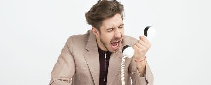 Hombre enfadado gritando al teléfono