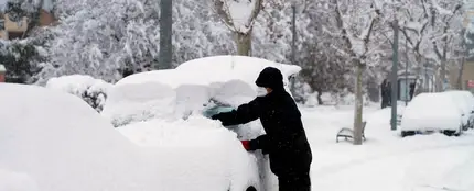 Un hombre quita la nieve de su coche Un hombre quita la nieve de su coche