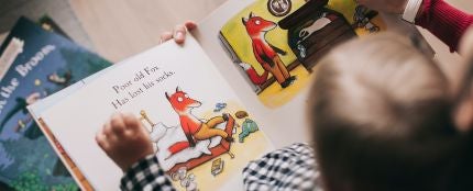 Un niño mirando un libro infantil