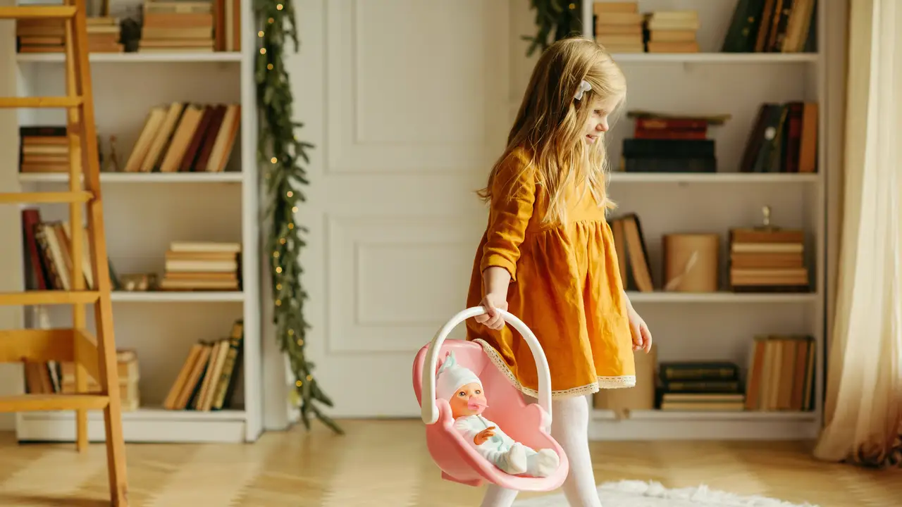 Una niña jugando con una muñeca Una niña jugando con una muñeca