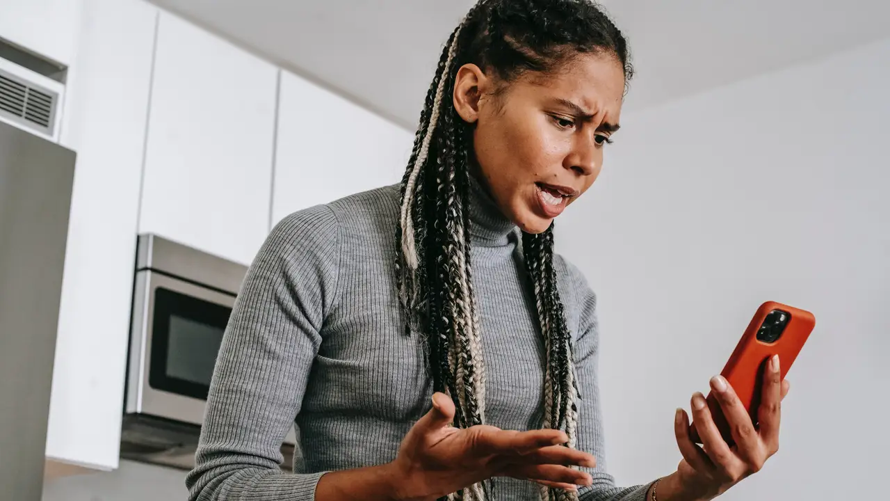 Mujer enfadada mirando el teléfono Mujer enfadada mirando el teléfono