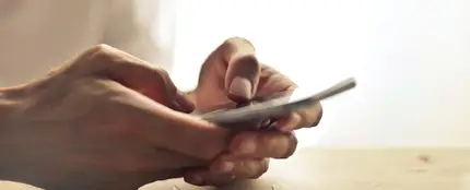 Una persona sostiene el teléfono móvil entre las manos Una persona sostiene el teléfono móvil entre las manos