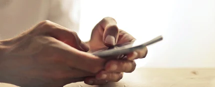 Una persona sostiene el teléfono móvil entre las manos Una persona sostiene el teléfono móvil entre las manos