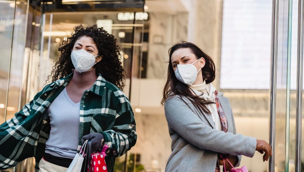 Dos chicas con mascarilla en la calle