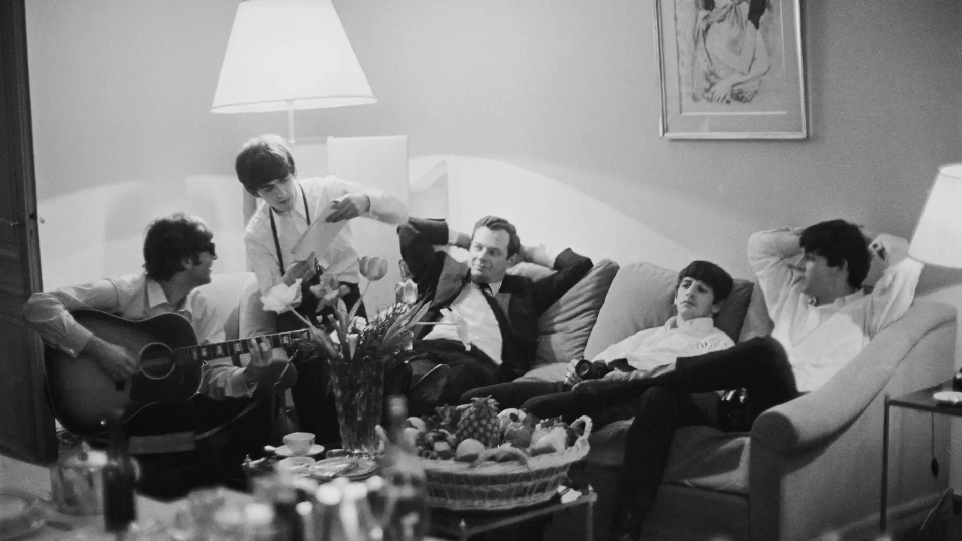 The Beatles con Brian Epstein en una habitación de hotel en 1964