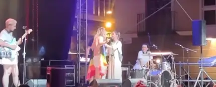 Una persona de la organización tapa a la cantante Rocío Saiz con una bandera LGTBI tras quitarse la camiseta. Una persona de la organización tapa a la cantante Rocío Saiz con una bandera LGTBI tras quitarse la camiseta.