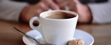 Un café, con una galleta y una cucharilla Un café, con una galleta y una cucharilla