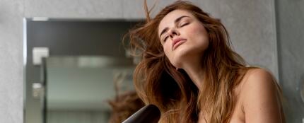 Una mujer secándose el pelo