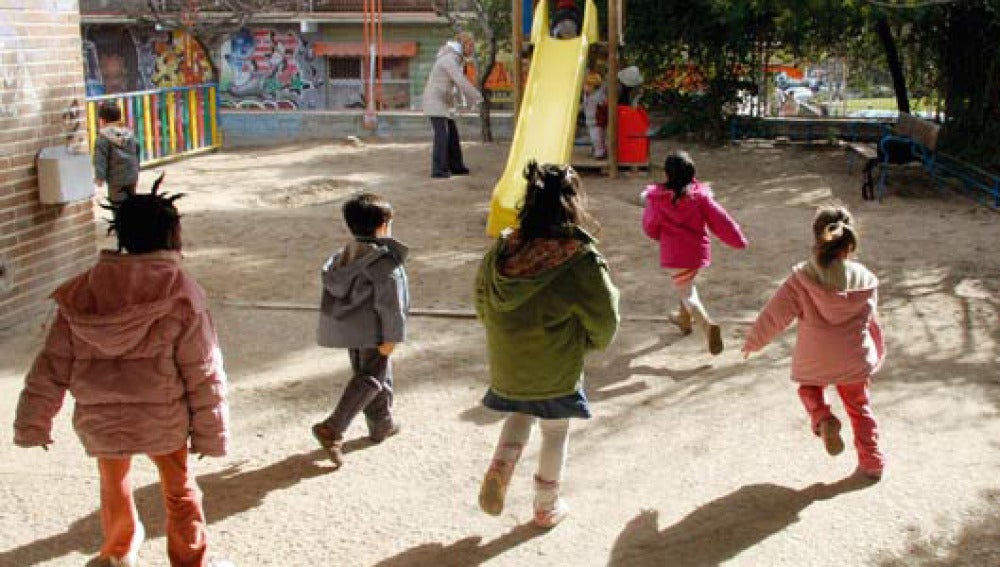 Varios niños salen a jugar a un parque infantil