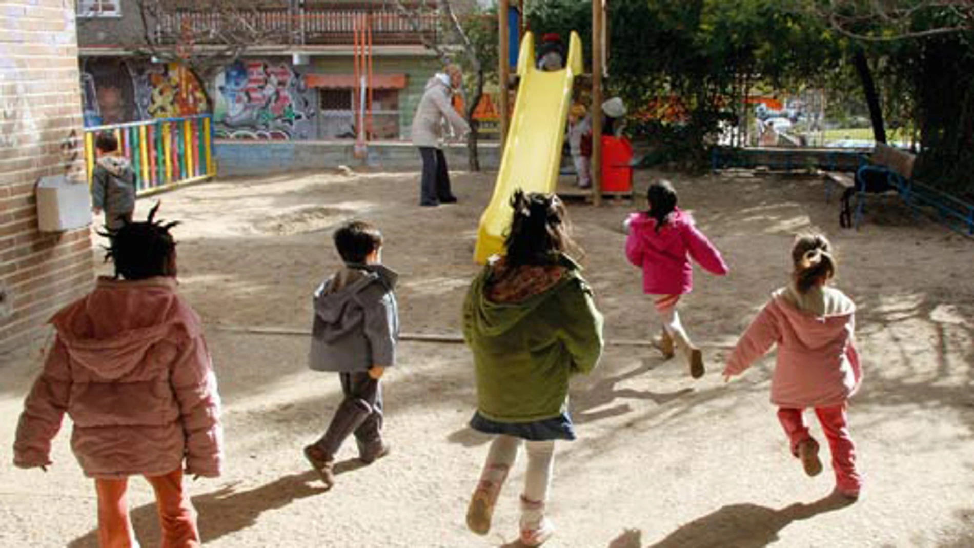 Varios niños salen a jugar a un parque infantil Varios niños salen a jugar a un parque infantil