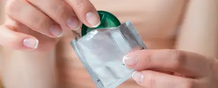 Mujer abriendo un preservativo Mujer abriendo un preservativo