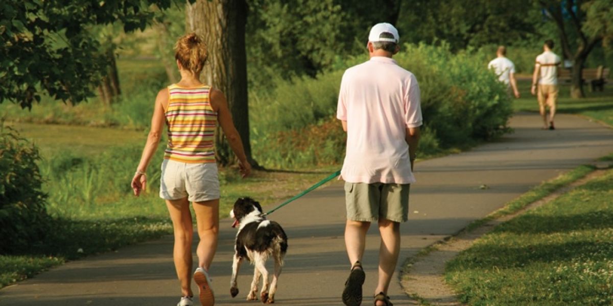 Un hombre y una mujer pasean con su perro