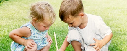 Imagen de dos niños jugando en el césped Imagen de dos niños jugando en el césped