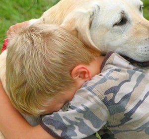 Un niño abraza a su perro Un niño abraza a su perro