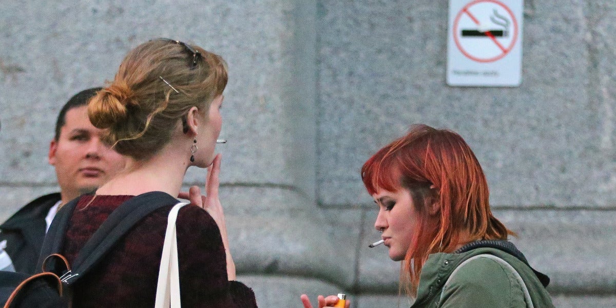Varios jóvenes fumando