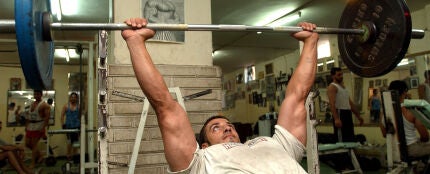 Un hombre trabaja con pesas en el gimnasio Un hombre trabaja con pesas en el gimnasio