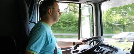 Un camionero con barriga conduciendo