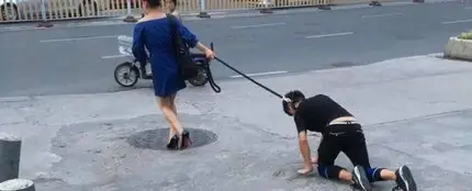 Una mujer china pasea a su novio con una correa como si fuera un perro Una mujer china pasea a su novio con una correa como si fuera un perro