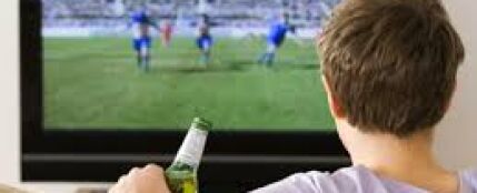 Hombre viendo un partido de fútbol por televisión