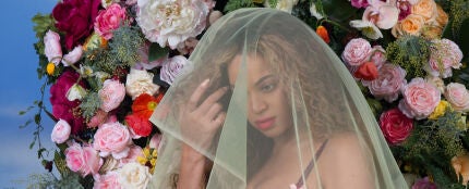 Beyonc&eacute; cubierta por un velo y con un fondo de flores