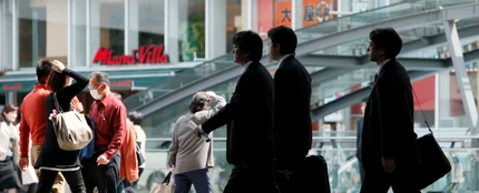 Empresarios caminan por una calle en Tokio (Japón) Empresarios caminan por una calle en Tokio (Japón)