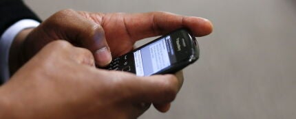 Un hombre utilizando un tel&eacute;fono m&oacute;vil