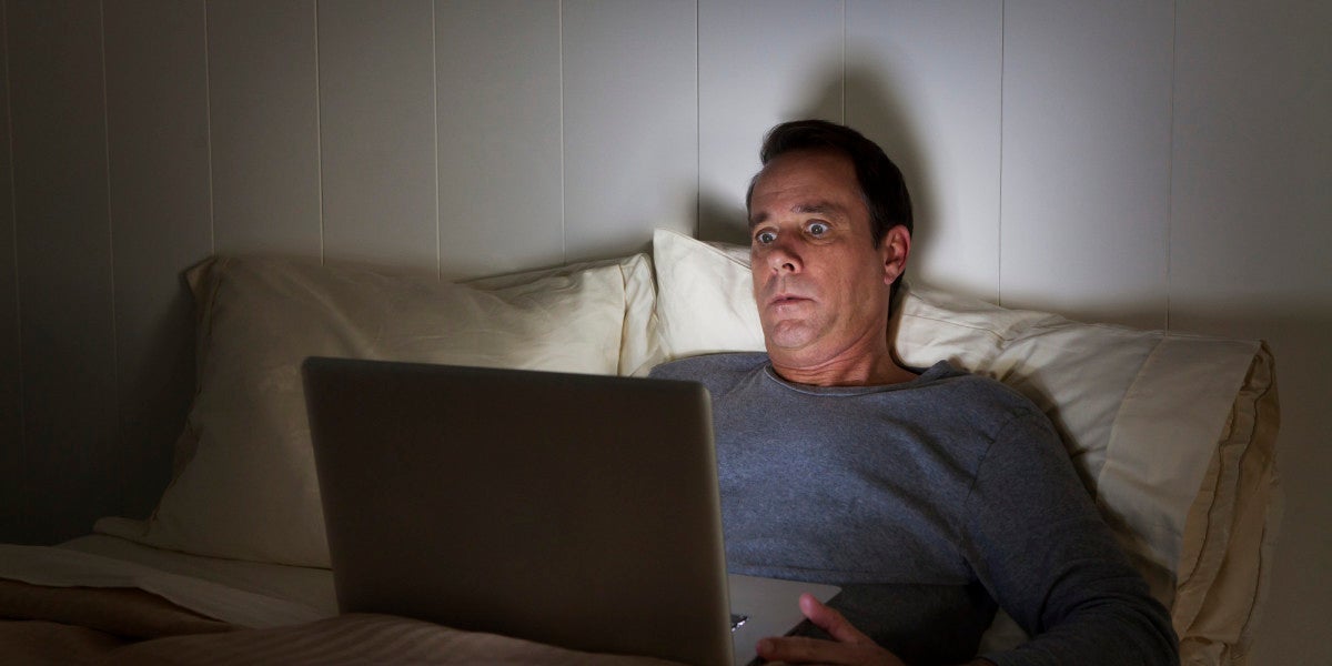 Hombre mirando su portátil sorprendido