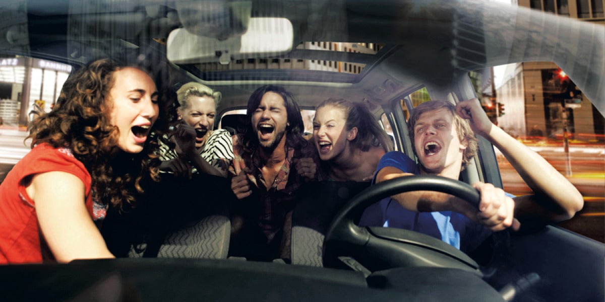 Un grupo de amigos cantando en el coche