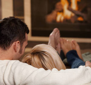 Pareja frente a la chimenea Pareja frente a la chimenea