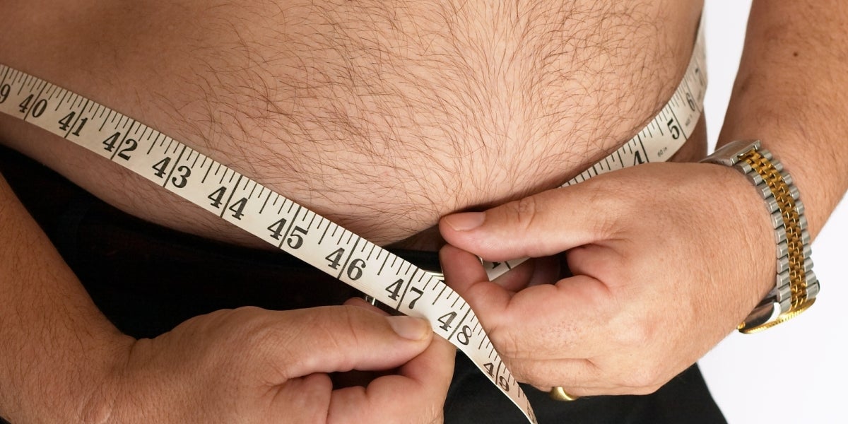Un hombre se mide la barriga