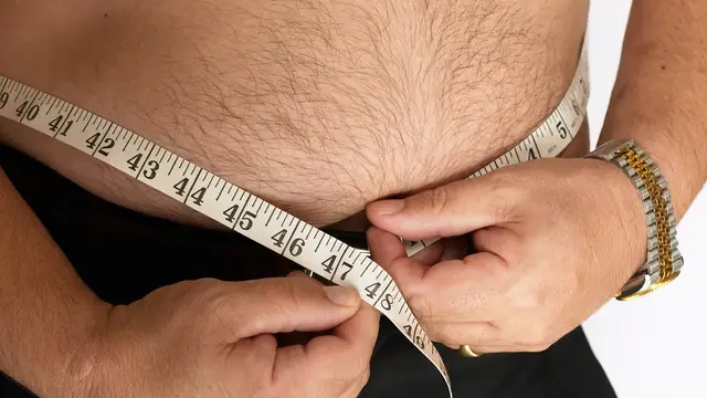 Un hombre se mide la barriga