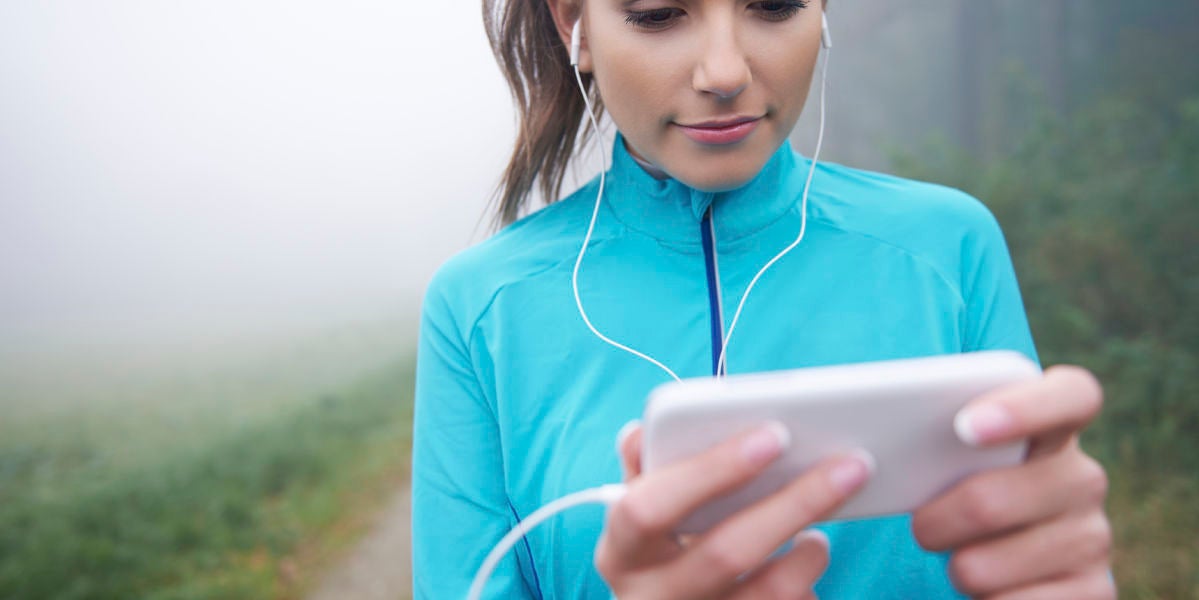 Una runner consulta su aplicación móvil