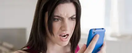 Mujer mirando el móvil enfadada Mujer mirando el móvil enfadada