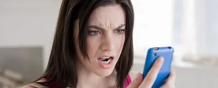 Mujer mirando el móvil enfadada Mujer mirando el móvil enfadada