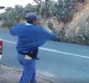 Un grupo de policías humilla tirando manzanas a unos hombres que habían detenido Un grupo de policías humilla tirando manzanas a unos hombres que habían detenido