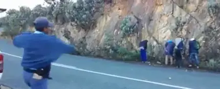 Un grupo de policías humilla tirando manzanas a unos hombres que habían detenido Un grupo de policías humilla tirando manzanas a unos hombres que habían detenido