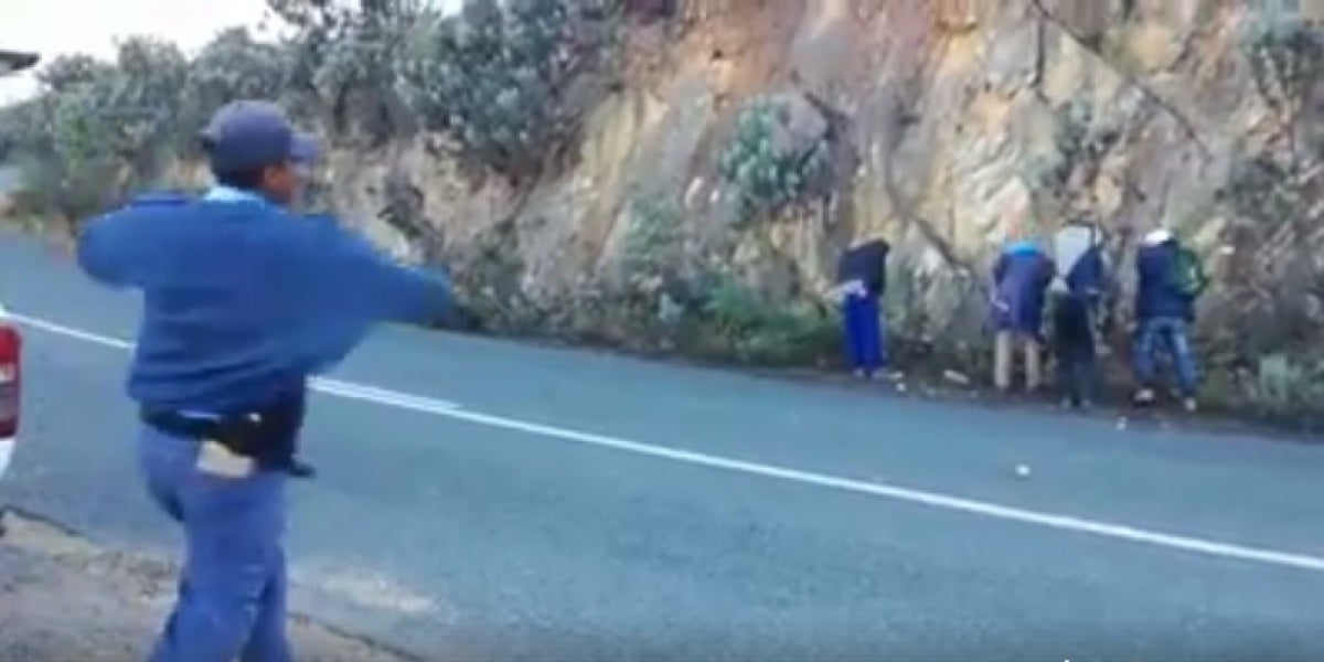 Un grupo de policías humilla tirando manzanas a unos hombres que habían detenido