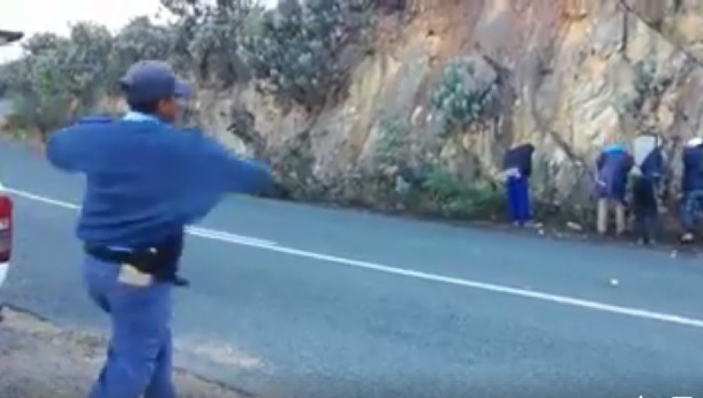 Un grupo de policías humilla tirando manzanas a unos hombres que habían detenido