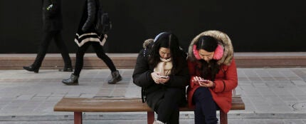 Mujeres chinas mirando su m&oacute;vil