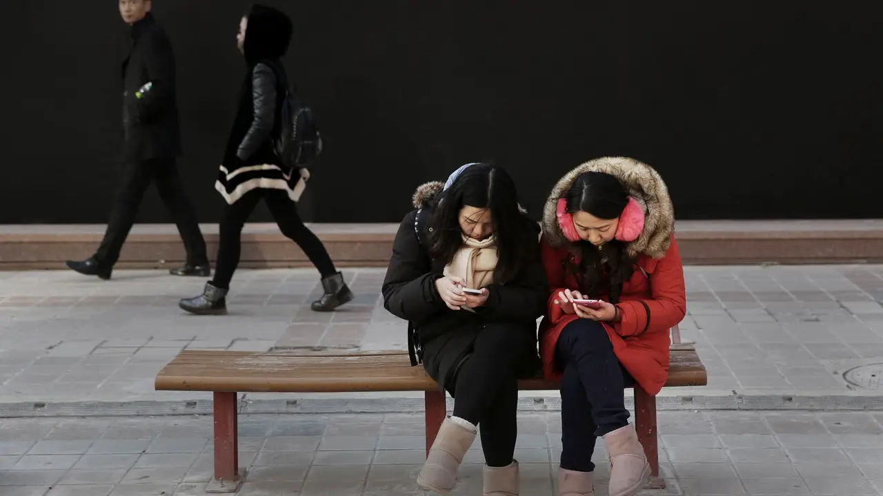 Mujeres chinas mirando su móvil Mujeres chinas mirando su móvil