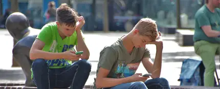 Dos amigosutilizando el móvil Dos amigosutilizando el móvil